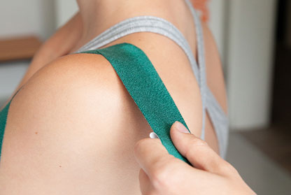 Kinesiotape wird auf Rücken angebracht